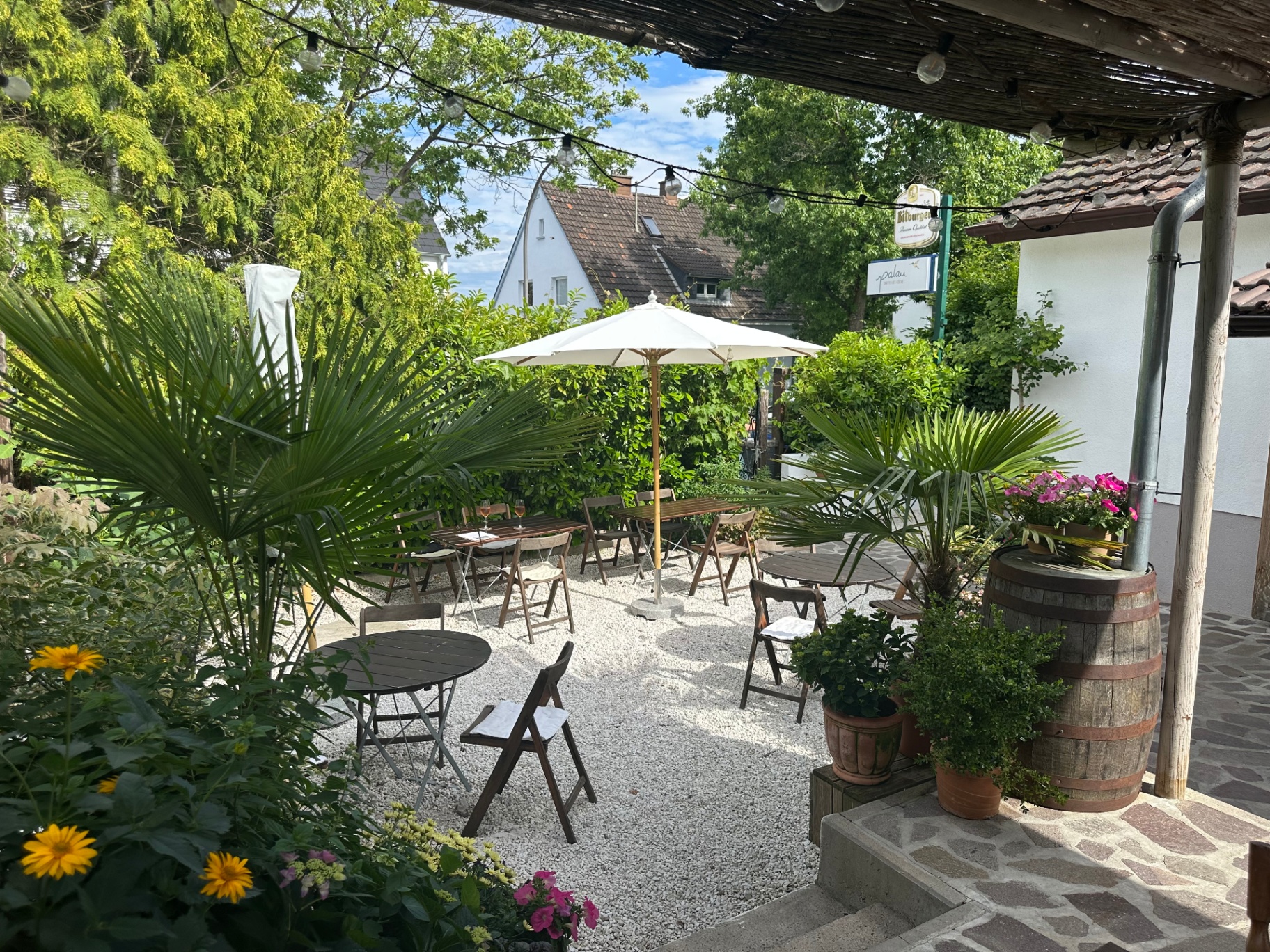 Gartenplätze mit Sonnenschirm, Palmen und Blumen im palau
